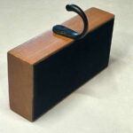 A unique, non-damaging hanging hook which can be moved as many times as you desire! This all wood block with a black iron hood will hold over 2 pounds when on a solid, level and flat surface. Perfect for displaying holiday decorations. Made by WDI.